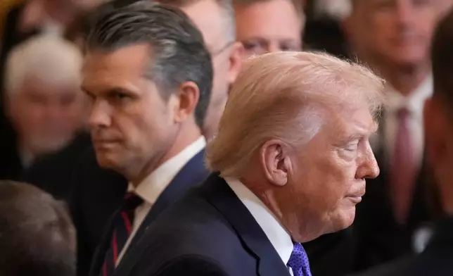 President Donald Trump walks past Defense Secretary Pete Hegseth as he exist the East Room of the White House following the Medal of Honor ceremony, Monday, March 2, 2026, in Washington. (AP Photo/Mark Schiefelbein)