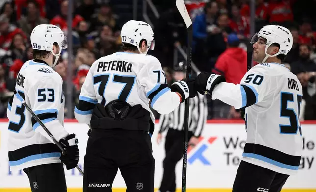 Utah Mammoth right wing JJ Peterka (77) celebrates his goal with left wing Michael Carcone (53) and defenseman Sean Durzi (50) during the second period of an NHL hockey game against the Washington Capitals, Tuesday, March 3, 2026, in Washington. (AP Photo/Nick Wass)
