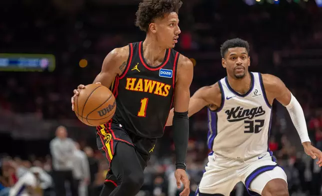 Atlanta Hawks forward Jalen Johnson (1) drives the ball against Sacramento Kings center Dylan Cardwell (32) during the first half of an NBA basketball game, Saturday, March 28, 2026, in Atlanta. (AP Photo/Erik Rank)