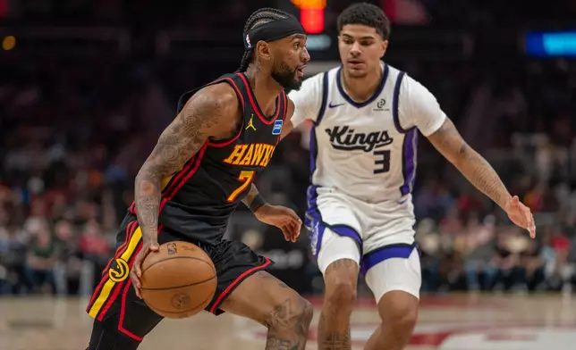 Atlanta Hawks guard Nickeil Alexander-Walker (7) drives the ball against Sacramento Kings guard Kililian Hays (3) during the first half of an NBA basketball game, Saturday, March 28, 2026, in Atlanta. (AP Photo/Erik Rank)