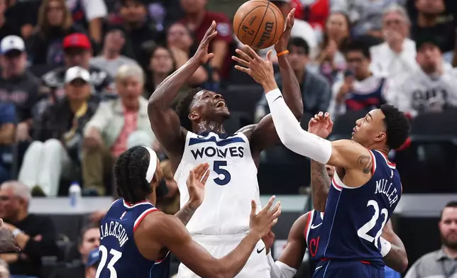 Minnesota Timberwolves guard Anthony Edwards (5) draws a foul against Los Angeles Clippers forward Isaiah Jackson (23) and guard Jordan Miller (22) during the first half of an NBA basketball game, Wednesday, March 11, 2026, in Inglewood, Calif. (AP Photo/Jessie Alcheh)