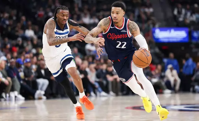 Los Angeles Clippers guard Jordan Miller (22) dribbles against Minnesota Timberwolves guard Bones Hyland, left, during the first half of an NBA basketball game, Wednesday, March 11, 2026, in Inglewood, Calif. (AP Photo/Jessie Alcheh)