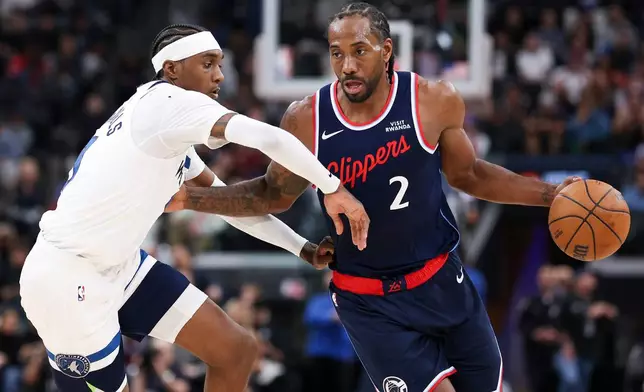 Los Angeles Clippers forward Kawhi Leonard (2) dribbles against Minnesota Timberwolves forward Jaden McDaniels, left, during the first half of an NBA basketball game, Wednesday, March 11, 2026, in Inglewood, Calif. (AP Photo/Jessie Alcheh)