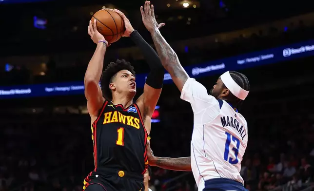 Atlanta Hawks forward Jalen Johnson (1) shoots against Dallas Mavericks forward Naji Marshall (13) during the first half of an NBA basketball game, Tuesday, March 10, 2026, in Atlanta. (AP Photo/Colin Hubbard)