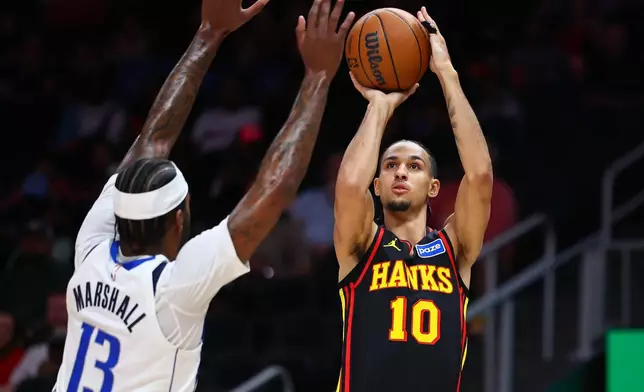 Atlanta Hawks forward Zaccharie Risacher (10) shoots against Dallas Mavericks forward Naji Marshall (13) during the first half of an NBA basketball game, Tuesday, March 10, 2026, in Atlanta. (AP Photo/Colin Hubbard)