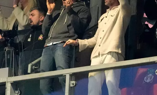 Wrexham co-owners Rob Mac, right, and Ryan Reynolds celebrate after VAR ruled Wrexham's goal onside during the fifth round FA Cup soccer match between Wrexham and Chelsea in Wrexham, Wales, Saturday, March 7, 2026. (Nick Potts/PA via AP)