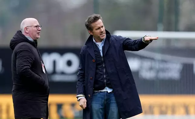 Wrexham co-owner Ryan Reynolds, right, with Wrexham Director Shaun Harvey on the pitch ahead of the English FA Cup fifth round soccer match between at Wrexham and Chelsea in Wrexham, Wales, Saturday March 7, 2026. (Martin Rickett/PA via AP)