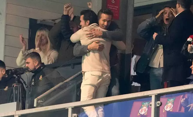 Wrexham co-owners Rob Mac, front, and Ryan Reynolds embrace after Wrexham scored during the fifth round FA Cup soccer match between Wrexham and Chelsea in Wrexham, Wales, Saturday, March 7, 2026. (Nick Potts/PA via AP)