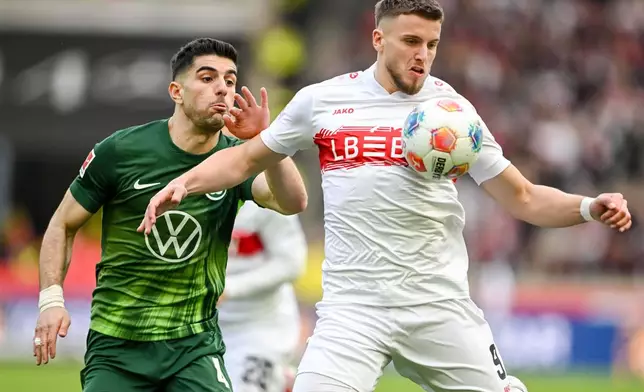 Wolfsburg's Konstantinos Koulierakis, left, in action against Stuttgart's Ermedin Demirovic during the German Bundesliga soccer match between VfB Stuttgart and VfL Wolfsburg in Stuttgart, Germany, Sunday, March 1, 2026. (Harry Langer/dpa via AP)