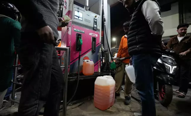 FILE - People store fuel in a plastic can at a petrol pump amid fears of a possible shortage due to the US Iran war, in Srinagar, Indian controlled Kashmir, Wednesday, March 25, 2026. (AP Photo/Mukhtar Khan, file)
