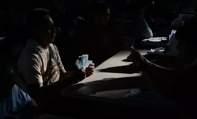 FILE - A jeepney driver poses after receiving cash assistance from the government to help in their livelihood as oil prices continue to rise, Wednesday, March 25, 2026, in Quezon city, Philippines. (AP Photo/Aaron Favila, file)