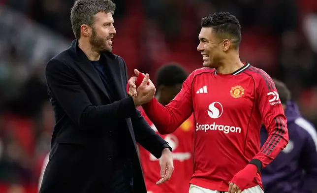 Manchester United's coach Michael Carrick and Casemiro walk off the pitch after during the Premiier League soccer match between Manchester United and Aston Villa in Manchester, England, Sunday, March 15, 2026. (AP Photo/Dave Thompson)