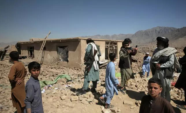 Residents inspect the site of a strike in Kabul, Afghanistan, Friday, March 13, 2026. (AP Photo/Barackatullah Popal)