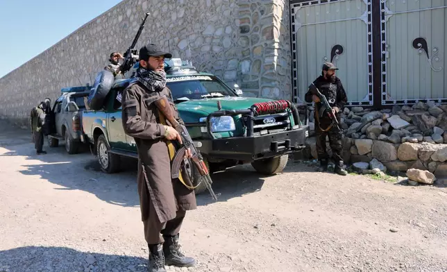 Taliban police guard the area where a strike hit a house in the Momand Dara district of Nangarhar province, Afghanistan, near the border with Pakistan, Friday, March 13, 2026. (AP Photo/Hedayat Shah)