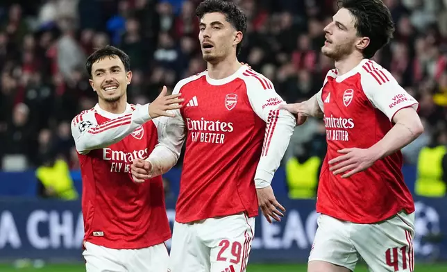 Arsenal's Kai Havertz, center, celebrates reserved beside Arsenal's Declan Rice, right, and Arsenal's Martin Zubimendi, left, after scoring a penalty against his former club during the Champions League round of 16 first leg soccer match between Bayer Leverkusen and Arsenal FC in Leverkusen, Germany, Wednesday, March 11, 2026. (AP Photo/Martin Meissner)