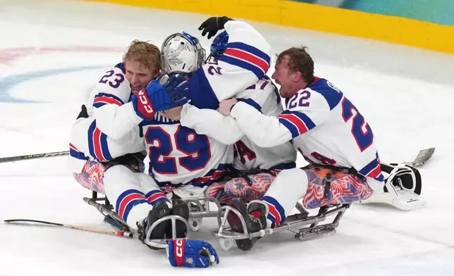 United States' players celebrates after winning the ice hockey gold medal match between United States and Canada at the 2026 Winter Paralympics, in Milan, Italy, Sunday, March 15, 2026. (AP Photo/Antonio Calanni)
