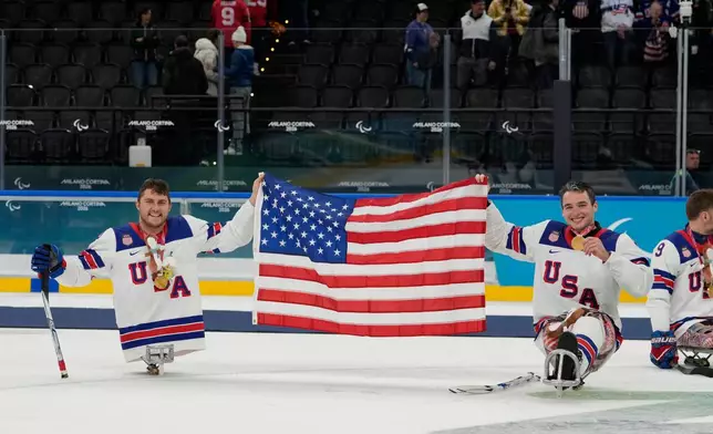 United States's Brody Roybal and his teammate Jack Wallace celebrate on the podium after winning the gold medal at the ice hockey of the 2026 Winter Paralympics, in Milan, Italy, Sunday, March 15, 2026. (AP Photo/Luca Bruno)