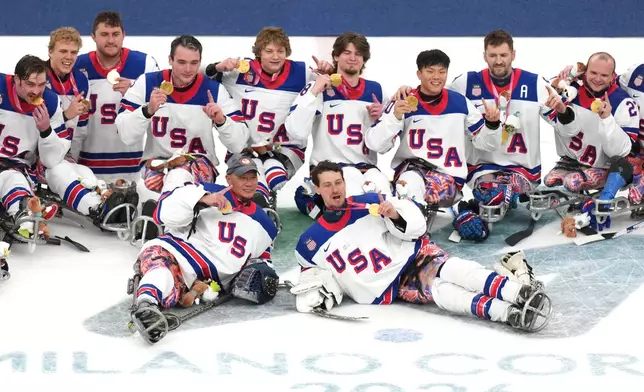 United States' players celebrate after winning the gold medal at the ice hockey final match between United States and Canada at the 2026 Winter Paralympics, in Milan, Italy, Sunday, March 15, 2026. (AP Photo/Antonio Calanni)