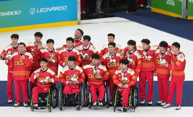 China's players celebrate after taking a bronze medal during the ice hockey bronze medal match between China and Czechia at the 2026 Winter Paralympics, in Milan, Italy, Sunday, March 15, 2026. (AP Photo/Antonio Calanni)