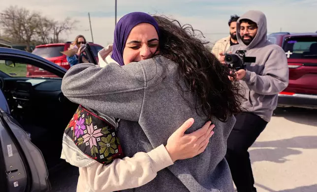 Leqaa Kordia, left, embraces friends, family and suppporters after being released from the Prairieland Detention Center in Alvarado, Texas, Monday, March 16, 2026. (AP Photo/Tony Gutierrez)