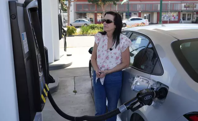 Leslie Sherman-Shafer, an Uber driver, fills up her car at a gas station in Alameda, Calif, March 23, 2026. (AP Photo/Terry Chea)