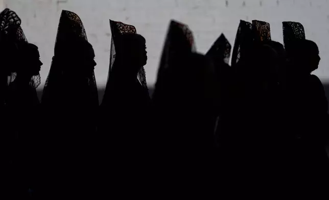 Women wearing traditional "mantillas" of the 'Franciscana de Pasion' brotherhood attend a Holy Week procession in Lucena, southern Spain, Monday, March 30, 2026. (AP Photo/Manu Fernandez)