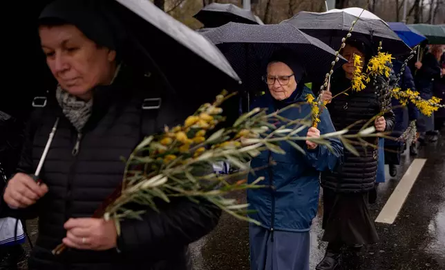 Catholic nuns walk during a Palm Sunday procession in Bucharest, Romania, Sunday, March 29, 2026. (AP Photo/Andreea Alexandru)