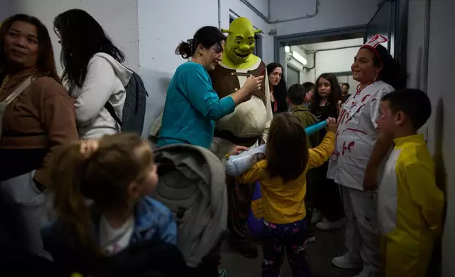 People, some wearing costumes, celebrate the Jewish holiday of Purim in an underground metro station used as a shelter against possible Iranian missile attacks, in Ramat Gan, Israel, Monday, March 2, 2026. (AP Photo/Oded Balilty)