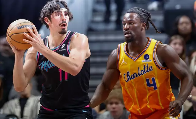 Miami Heat forward Jaime Jaquez Jr. (11) looks to pass the ball against Charlotte Hornets guard Sion James (4) during the first half of an NBA basketball game in Charlotte, N.C., Friday, March 6, 2026. (AP Photo/Nell Redmond)
