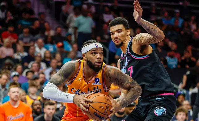 Charlotte Hornets forward Miles Bridges, left, drives against Miami Heat center Kel'el Ware during the first half of an NBA basketball game in Charlotte, N.C., Friday, March 6, 2026. (AP Photo/Nell Redmond)