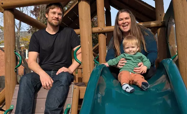 FILE - Thea Price, top right, whose family is moving away from the Washington region and back to her hometown of Seattle after losing their jobs and relying on savings and food assistance programs like SNAP, poses for a photo on a playground with her husband Nikita and 10-month old boy Nikolai, in Arlington, Va., Nov. 7, 2025. (AP Photo/Nathan Ellgren, file)