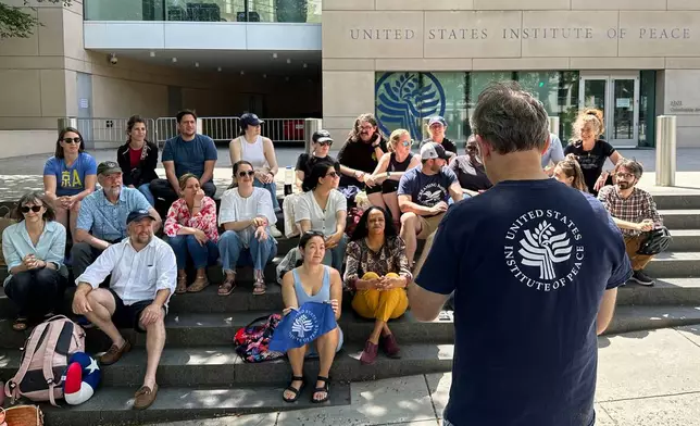 FILE - U.S. Institute of Peace employees hold an impromptu celebration on the steps of the U.S. Institute of Peace, May 19, 2025, in Washington. (AP Photo/Gary Fields, file)