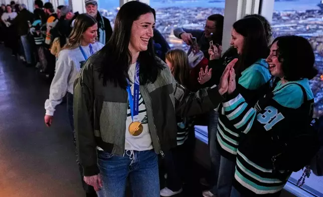 United States women's gold medal hockey players Megan Keller, center, and Haley Winn, rear left, are greeted during a gathering with fans, Monday, March 2, 2026, in Boston. (AP Photo/Charles Krupa)