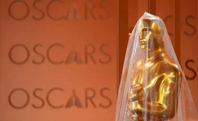 Oscar statue is protected by plastic in the red carpet area, Friday, March 13, 2026, at the Dolby Theatre in Los Angeles in preparation for Sunday's 98th Academy Awards ceremony. (AP Photo/Chris Pizzello)
