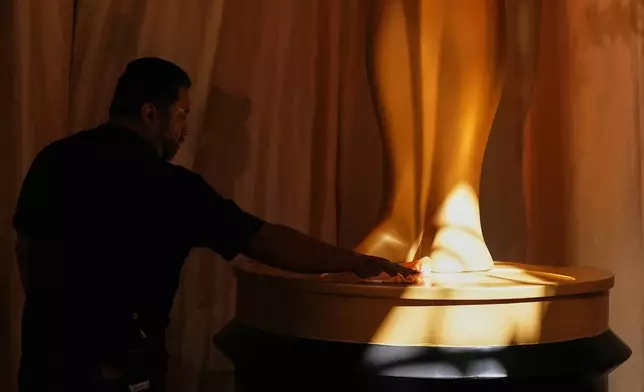 Alex Cortez polishes the base of an Oscar statue at the Dolby Theatre in Los Angeles, Saturday, March 14, 2026, in preparation for Sunday's 98th Academy Awards ceremony. (AP Photo/Gregory Bull)