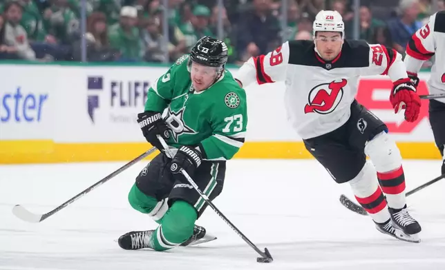 Dallas Stars left wing Adam Erne (73) is tripped up by New Jersey Devils right wing Timo Meier (28) during the first period of an NHL hockey game Tuesday, March 24, 2026, in Dallas. (AP Photo/Julio Cortez)