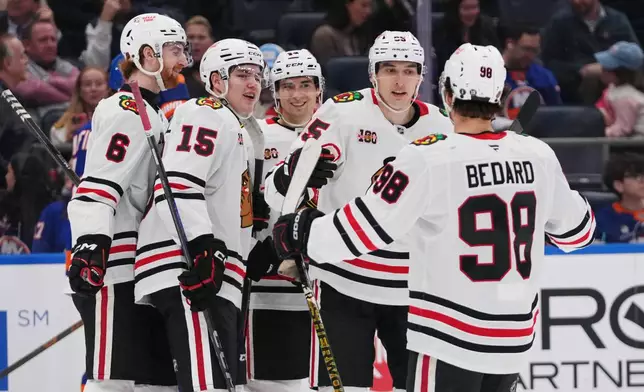 Chicago Blackhawks' Ilya Mikheyev (95) celebrates with teammates Sam Rinzel (6), Anton Frondell (15), Connor Bedard (98) and Wyatt Kaiser after scoring a goal during the first period of an NHL hockey game Tuesday, March 24, 2026, in Elmont, N.Y. (AP Photo/Frank Franklin II)
