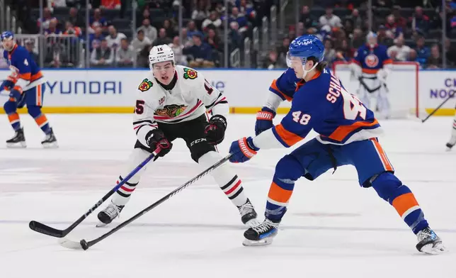Chicago Blackhawks' Anton Frondell (15) fights for control of the puck with New York Islanders' Matthew Schaefer (48) during the second period of an NHL hockey game Tuesday, March 24, 2026, in Elmont, N.Y. (AP Photo/Frank Franklin II)
