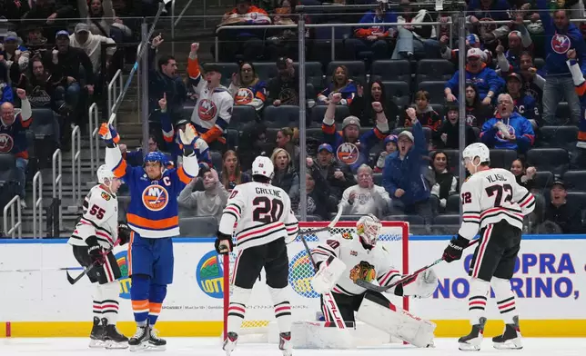 New York Islanders' Anders Lee, left, celebrates after scoring a goal as Chicago Blackhawks goaltender Arvid Soderblom, Ryan Greene (20) and Alex Vlasic (72) react during the first period of an NHL hockey game Tuesday, March 24, 2026, in Elmont, N.Y. (AP Photo/Frank Franklin II)