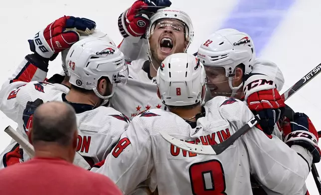 FILE - Washington Capitals left wing Alex Ovechkin (8) celebrates with right wing Tom Wilson, defenseman John Carlson, top, and center Evgeny Kuznetsov after Ovechkin scored against the Nashville Predators during the third period of an NHL hockey game, Feb. 15, 2022, in Nashville, Tenn. (AP Photo/Mark Zaleski, File)