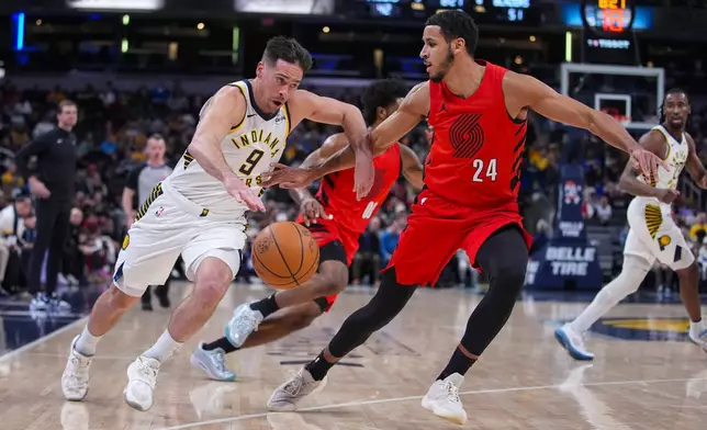 Indiana Pacers guard T.J. McConnell (9) drives on Portland Trail Blazers forward Kris Murray (24) during the first half of an NBA basketball game in Indianapolis, Wednesday, March 18, 2026. (AP Photo/Michael Conroy)