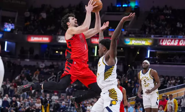 Portland Trail Blazers forward Deni Avdija (8) draws the foul from Indiana Pacers guard Kam Jones (7) as he shoots during the second half of an NBA basketball game in Indianapolis, Wednesday, March 18, 2026. (AP Photo/Michael Conroy)