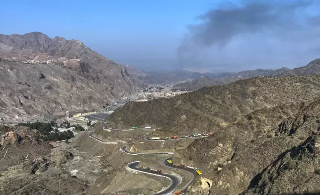 Smoke emits from Afghan side as trucks are parked along roadside following cross-border clashes between Pakistan and Afghan forces, at near Torkham border crossing point, Pakistan, Saturday, Feb. 28, 2026. (AP Photo/Maaz Awan)