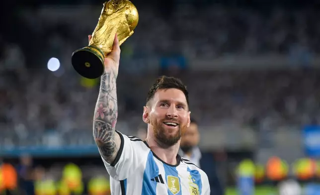 FILE - Argentina's Lionel Messi hoists the winning team replica of the FIFA World Cup trophy during a celebration ceremony for local fans after an international friendly soccer match against Panama at the Monumental stadium in Buenos Aires, Argentina, March 23, 2023. (AP Photo/Gustavo Garello, file)