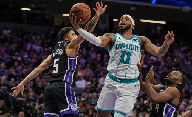 Charlotte Hornets forward Miles Bridges (0) goes for a layup against Sacramento Kings guard Nique Clifford (5) during the second half of an NBA basketball game, Wednesday, March 11, 2026, in Sacramento, Calif. (AP Photo/Justine Willard)