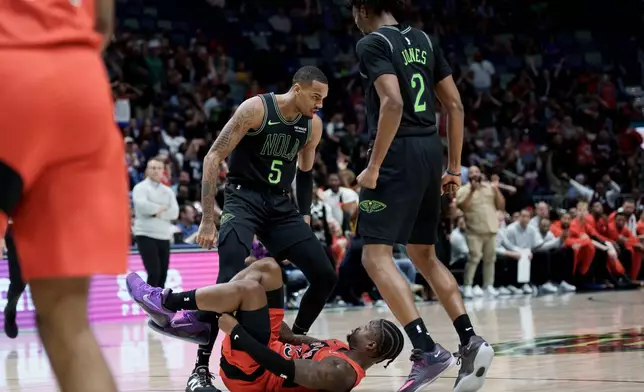 New Orleans Pelicans guard Dejounte Murray (5) stands over Toronto Raptors guard Jamal Shead (23) next forward Herbert Jones (2) after Shead fell while trying to defend against the three point basket of Murray during the second half of an NBA basketball game in New Orleans, Wednesday, March 11, 2026. Murray received a technical foul after standing over him. (AP Photo/Matthew Hinton)