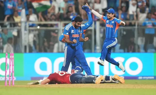 India's Jasprit Bumrah, left, and teammates celebrate the run out of England's Jacob Bethell, on ground, during the T20 World Cup cricket semi-final match between India and England in Mumbai, India, Thursday, March 5, 2026. (AP Photo/Rafiq Maqbool)