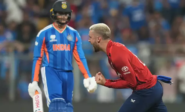 England's Will Jacks, right, celebrates the dismissal of India's Abhishek Sharma, left, during the T20 World Cup cricket semi-final match between India and England in Mumbai, India, Thursday, March 5, 2026. (AP Photo/Rafiq Maqbool)