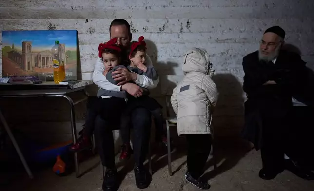 People take cover in a bomb shelter as air raid sirens warn of incoming Iranian missile strikes in Bnei Brak, Israel, Wednesday, March 25, 2026. (AP Photo/Ohad Zwigenberg)