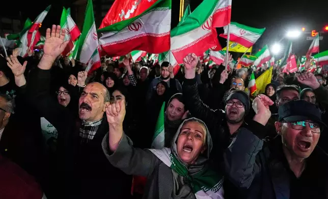 Pro-government supporters chant slogans and wave Iranian flags during a rally, in a square in western Tehran, Iran, Wednesday, March 25, 2026. (AP Photo/Vahid Salemi)